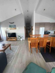Eaglerock Guesthouse and tours في كيركجوباجاركلوستر: غرفة معيشة مع طاولة وكراسي خشبية