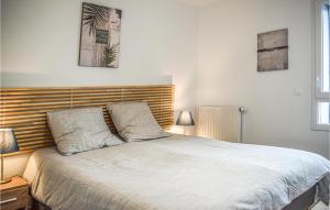 a bedroom with a bed with a wooden headboard at Stunning Apartment In Saint Quay Portrieux With House Sea View in Saint-Quay-Portrieux