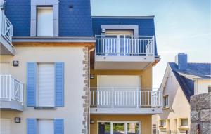 an apartment building with balconies and blue shutters at Stunning Apartment In Saint Quay Portrieux With House Sea View in Saint-Quay-Portrieux