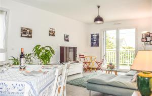 a kitchen and living room with a table and a couch at Stunning Apartment In Saint Quay Portrieux With House Sea View in Saint-Quay-Portrieux