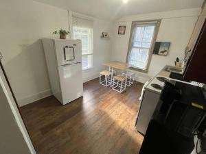 a kitchen with a white refrigerator and a table at Lovely Rural 1 Bedroom Apartment in St Mary’s in Saint Marys