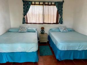 een slaapkamer met 2 bedden en een raam bij Monterrico Casablanca in Chiquimulilla