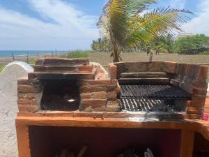 un horno de ladrillo al aire libre con una palmera en el fondo en Monterrico Casablanca, en Chiquimulilla