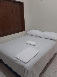 uma cama com duas almofadas em cima em L & C - Casa por Temporada em Macapá