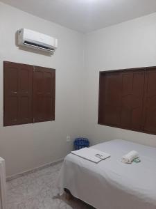 a bedroom with a bed and a air conditioner on the wall at L & C - Casa por Temporada in Macapá