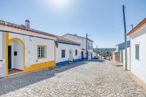 uma rua numa cidade com edifícios brancos e azuis em Lugar do Regato - Alojamento Local em Portel