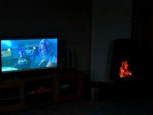 TV en la sala de estar con chimenea. en Apartment with lake view in Jølster, en Årdal