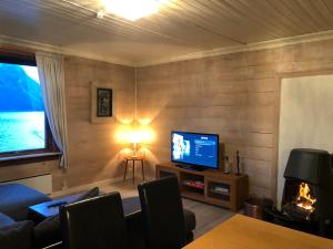 sala de estar con TV y chimenea en Apartment with lake view in Jølster en Årdal
