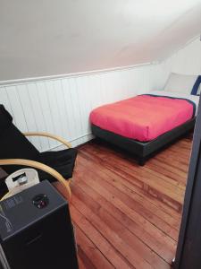 a small room with a bed and a desk at Hostal Capricho de Carlitos in Valdivia