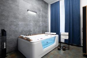 uma banheira na casa de banho com cortinas azuis em Szampan i Truskawka em Toruń