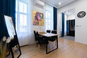 a dining room with a table and chairs and a clock at Szampan i Truskawka in Toruń