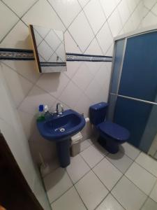 uma casa de banho com um lavatório azul e um WC. em L & C - Casa por Temporada em Macapá