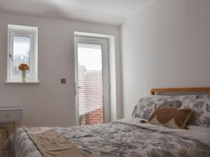 a bedroom with a bed and a window at Secretseaview in West Mersea