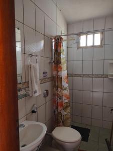 a bathroom with a toilet and a sink at Pousada Carmel Garden in Pirenópolis