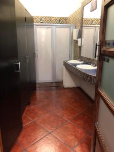 a bathroom with two sinks and a tiled floor at Hostal Cielito De María in Zacatecas