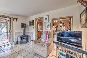 uma sala de estar com uma televisão de ecrã plano e uma lareira em Cozy High Rolls Cottage with Fire Pit and Gas Grill! em Cloudcroft