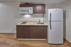 a kitchen with a white refrigerator and a sink at Extended Suites Cancun Cumbres in Cancún