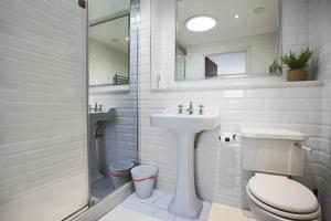a white bathroom with a sink and a toilet at Luxury Penthouse Apartment - Central MK - Pool Table, Balcony, Fast WiFi, Free Parking and Smart TVs with Sky TV and Netflix by Yoko Property in Milton Keynes