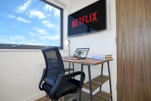 an office with a desk and a netflix sign on a wall at Luxury Penthouse Apartment - Central MK - Pool Table, Balcony, Fast WiFi, Free Parking and Smart TVs with Sky TV and Netflix by Yoko Property in Milton Keynes