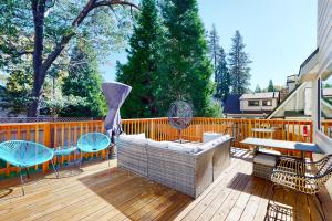 a patio with a couch and tables and chairs on a wooden deck at Hemlock Haven in Lake Arrowhead