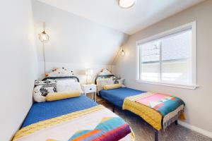 two twin beds in a room with a window at Hemlock Haven in Lake Arrowhead