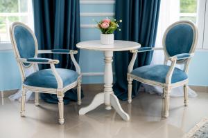 dos sillas y una mesa con un jarrón de flores en Vila Biser Dunava (Pearl of Danube Villa) en Smederevo