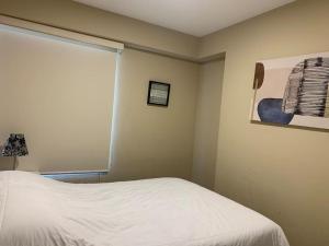 ein Schlafzimmer mit einem weißen Bett und einem Fenster in der Unterkunft MLA apartments - Kennedy in Lima