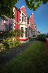una fila de casas con pintura roja y blanca en Jardine Apartment @ Cairn Dhu House en Stornoway