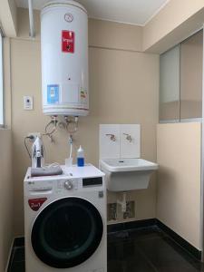 a kitchen with a washing machine and a sink at MLA apartments - Kennedy in Lima