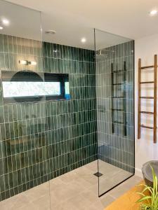 a bathroom with a shower with green tiled walls at Weavers Rest in Biddenden