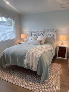 a bedroom with a bed with two lamps and a window at Right on Tyne in Oamaru