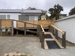 a wooden ramp leading to a house with a fence at Right on Tyne in Oamaru