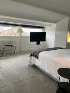 a bedroom with a bed and a flat screen tv at La Villa Bocage in Bordeaux