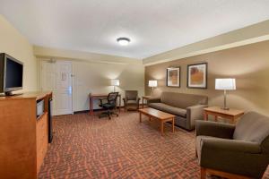 Habitación de hotel con sofá y TV en Best Western Louisville East Inn & Suites, en Louisville