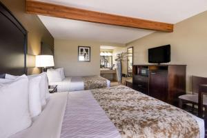 a hotel room with two beds and a flat screen tv at Best Western Weston Inn in West Yellowstone