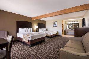 una camera d'albergo con due letti e un divano di Best Western Weston Inn a West Yellowstone