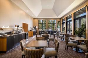 a restaurant with tables and chairs and a kitchen at Best Western Windsor Inn in Ashland
