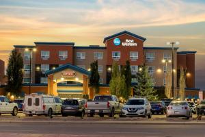 a hotel with a lot of cars parked in a parking lot at Best Western Cold Lake Inn in Cold Lake