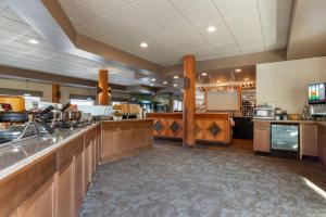 a large kitchen with wooden cabinets and a bar at BEST WESTERN PLUS Valemount Inn & Suites in Valemount