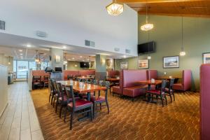 a restaurant with wooden tables and red chairs at Best Western Plus Dryden Hotel and Conference Centre in Dryden