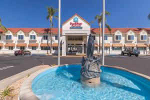 a statue in the water in front of a hotel at SureStay Plus Hotel by Best Western Upland - Ontario North in Upland