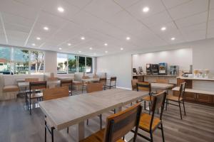 a dining room with tables and chairs and windows at SureStay Plus Hotel by Best Western Upland - Ontario North in Upland