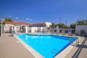 a large swimming pool with chairs around it at SureStay Plus Hotel by Best Western Upland - Ontario North in Upland