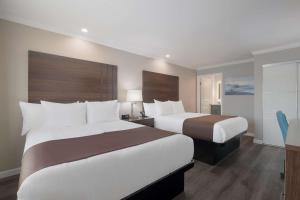 a hotel room with two beds and a window at SureStay Plus Hotel by Best Western Upland - Ontario North in Upland