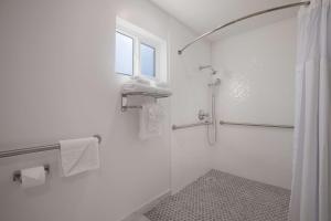 a white bathroom with a shower and a window at SureStay Plus Hotel by Best Western Upland - Ontario North in Upland
