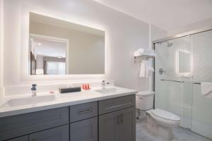 a bathroom with a sink and a toilet and a mirror at SureStay Plus Hotel by Best Western Upland - Ontario North in Upland