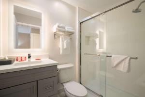 a bathroom with a shower and a toilet and a sink at SureStay Plus Hotel by Best Western Upland - Ontario North in Upland