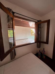 a bedroom with a window and a bed in it at Vila Moana Jeri in Jericoacoara