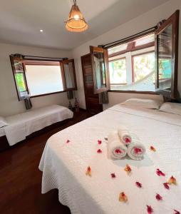 ジェリコアコアラにあるVila Moana Jeriのベッドルーム1室(シーツに花を飾ったベッド2台付)