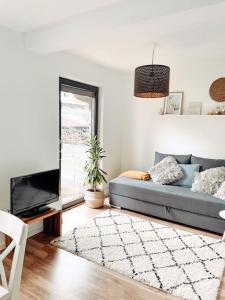 uma sala de estar com um sofá azul e uma televisão em *TOP*+Allgäu*Familie*NETFLIX*mit Garten & *PS4* em Kaufbeuren